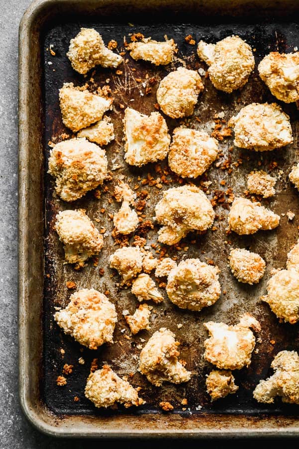 Buffalo Cauliflower takes all your favorite things about buffalo chicken wings - the crispy exterior, soft interior, and tangy, spicy buffalo taste - and turns them into a healthier option you don't have to feel guilty about eating. Super easy and so good! Baked cauliflower on a sheet pan