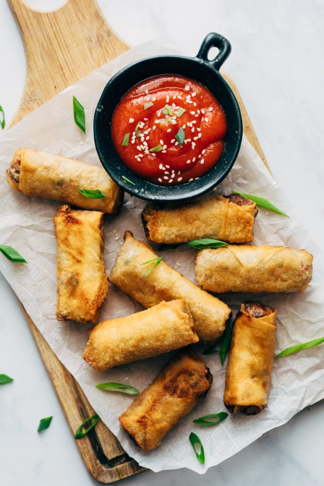 Egg Rolls - make your favourite takeout appetizer at home now! It's incredibly easy, they freeze well and taste absolutely amazing! Egg rolls served with sweet spicy sauce