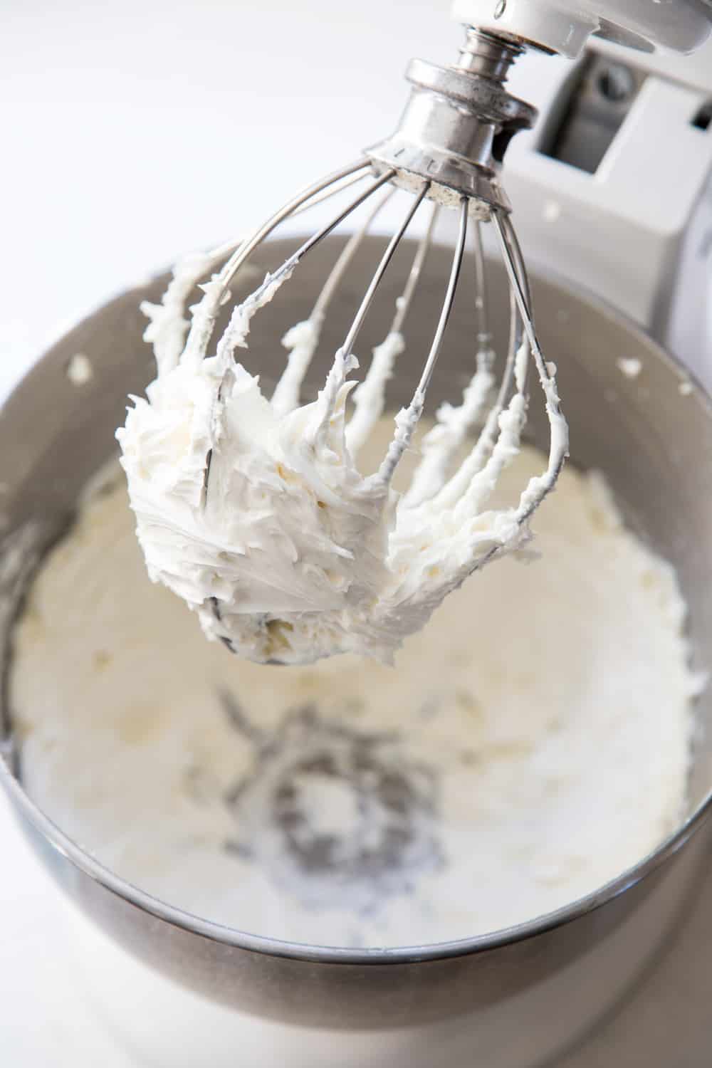 Easy Vanilla Cupcakes with vanilla frosting are such a classic treat for birthdays and perfect for any celebratory occasions. These moist cupcakes with their creamy crown of frosting will surely bring a smile to your face! Vanilla buttercream frosting in a stand mixer bowl