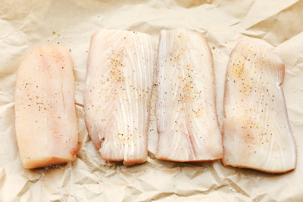 Mahi Mahi is aย tender filet cooked golden brown then in soaked in a brown butter sauce and garnished with a fresh avocado salsa. Anย irresistible Dinner! A row of four Mahi Mahi filets seasoned with salt and pepper.