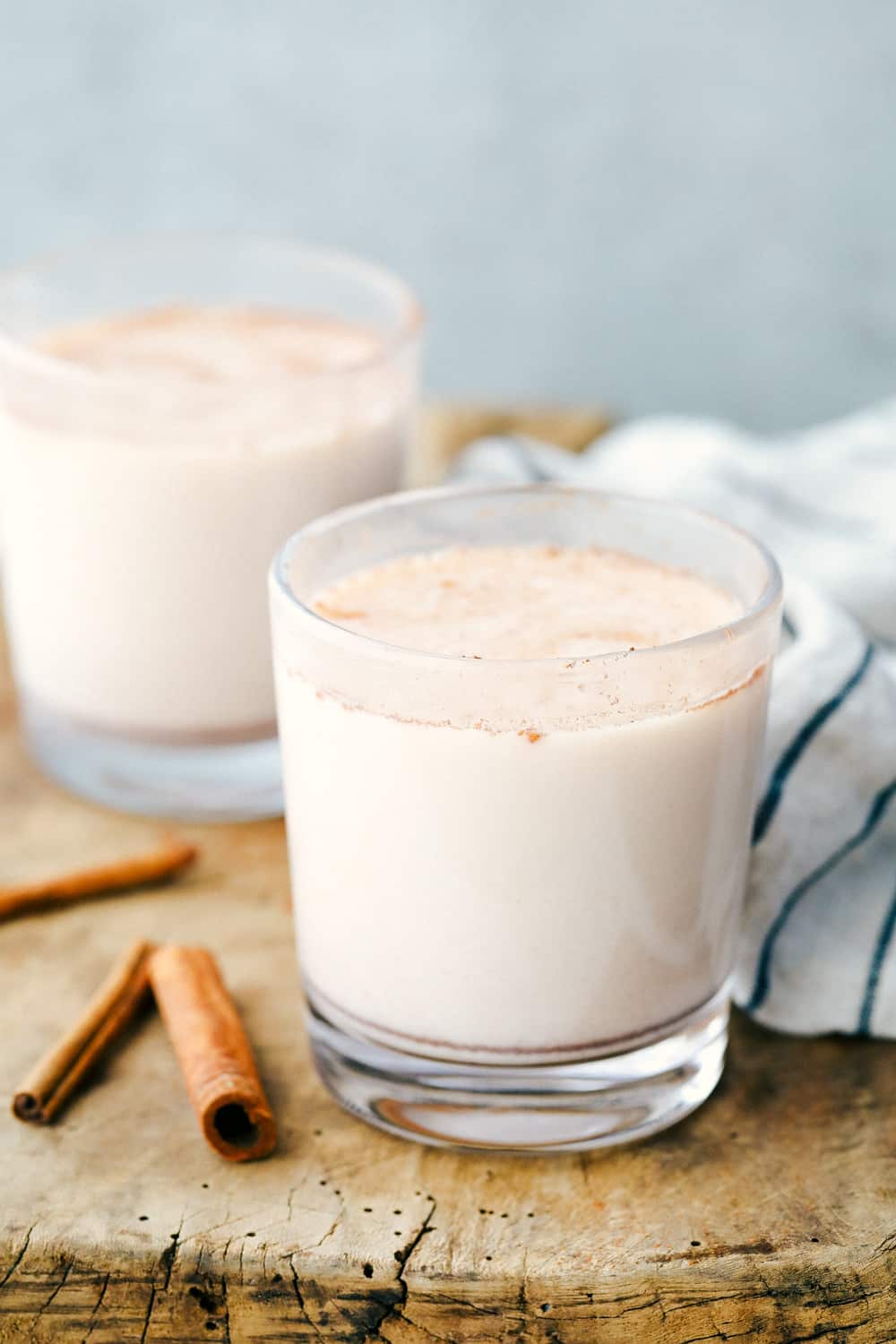 Best Ever Horchata is a smooth andย creamy cold drink that blends rice soaked in water and sweetened with cinnamon making this authentic Mexican drink rich and milky. Aย delicious sweet cinnamon flavored Mexican drink!ย Two glasses full of horchata with cinnamon sticks laying next to the glasses as garnish.