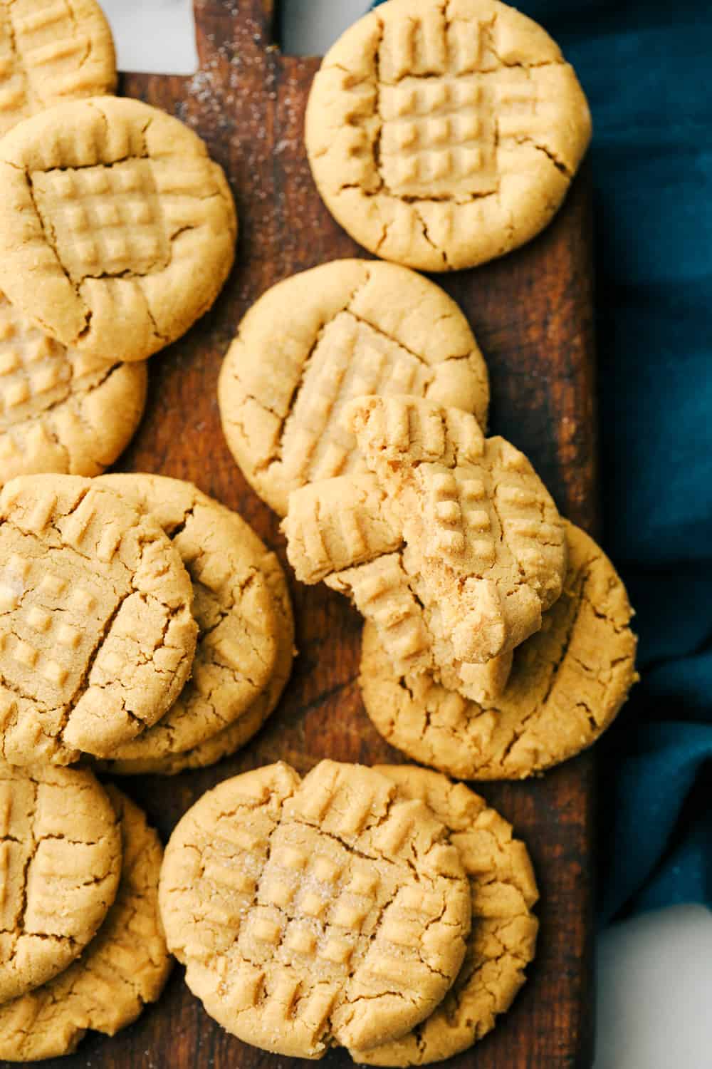 Easy 3 Ingredient Peanut Butter Cookies are soft, fluffy and full ofย creamy peanut butter with sweet sugar and a large egg, it is that simple. Only 3 Ingredients to make theseย deliciously desirable cookies!ย 3 Ingredient peanut butter cookies baked an on a cutting board.