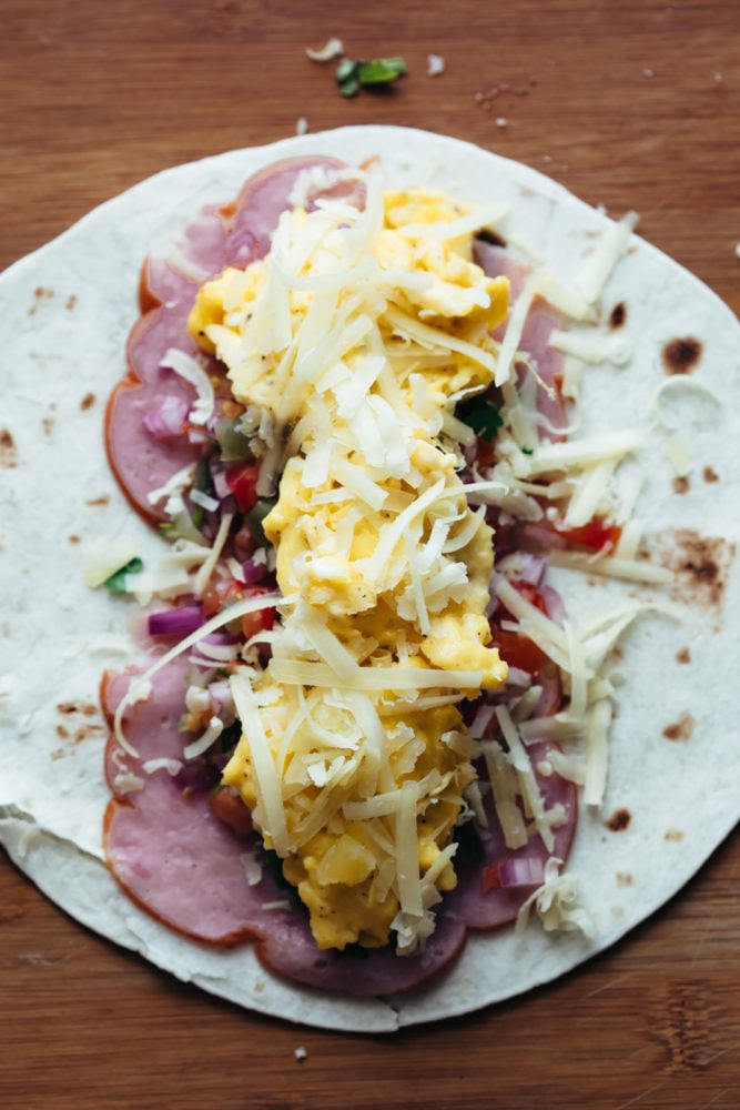 These breakfast burritos are freezer friendly and stuffed with scrambled eggs, deli ham, pico de gallo and plenty of cheese. Filling inside a breakfast burrito