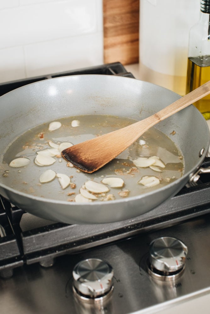 Classic Shrimp Scampi is a delicious recipe of pan-cooked shrimp drenched in decadent garlic butter and lemon sauce. This simple shrimp dish is made in minutes and is best served over pasta or with crusty bread for dipping. scampi sauce cooking on stove