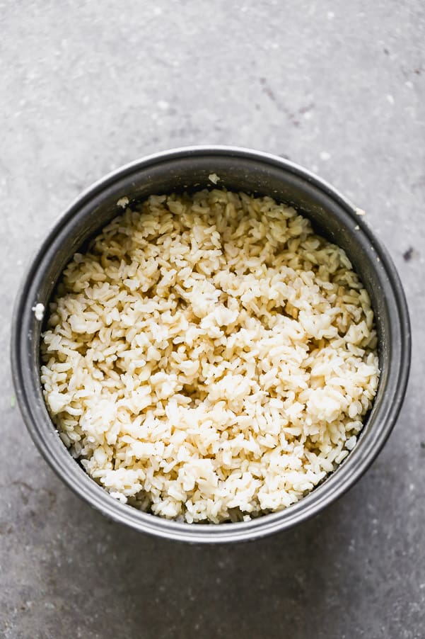This easy Poke Bowl Recipe ย is packed with sushi-grade ahi tuna seasoned with soy, honey, and plenty of sesame. It's served with sticky brown rice, tons of veggies and these easiest spicy mayo on the planet.ย Cooked rice in a pan.