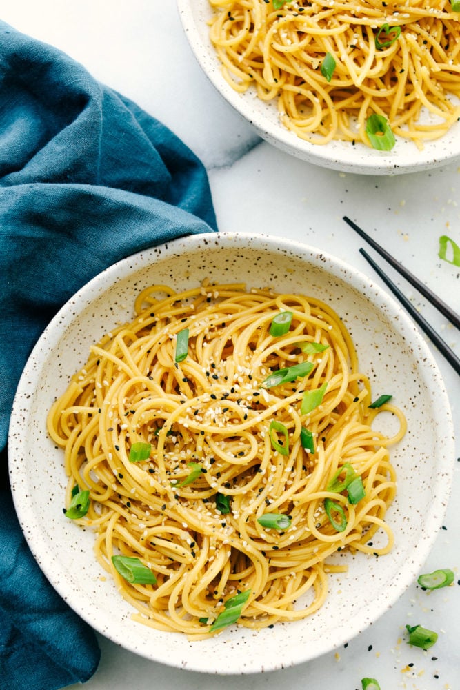 A quick and easy garlic sesame noodle recipe that is light and tasty! Add in vegetables and protein to enhance this oriental dish or keep it simple with a garlic sesame flavoring.ย Overhead photo shot with Garlic sesame noodles in a bowl.