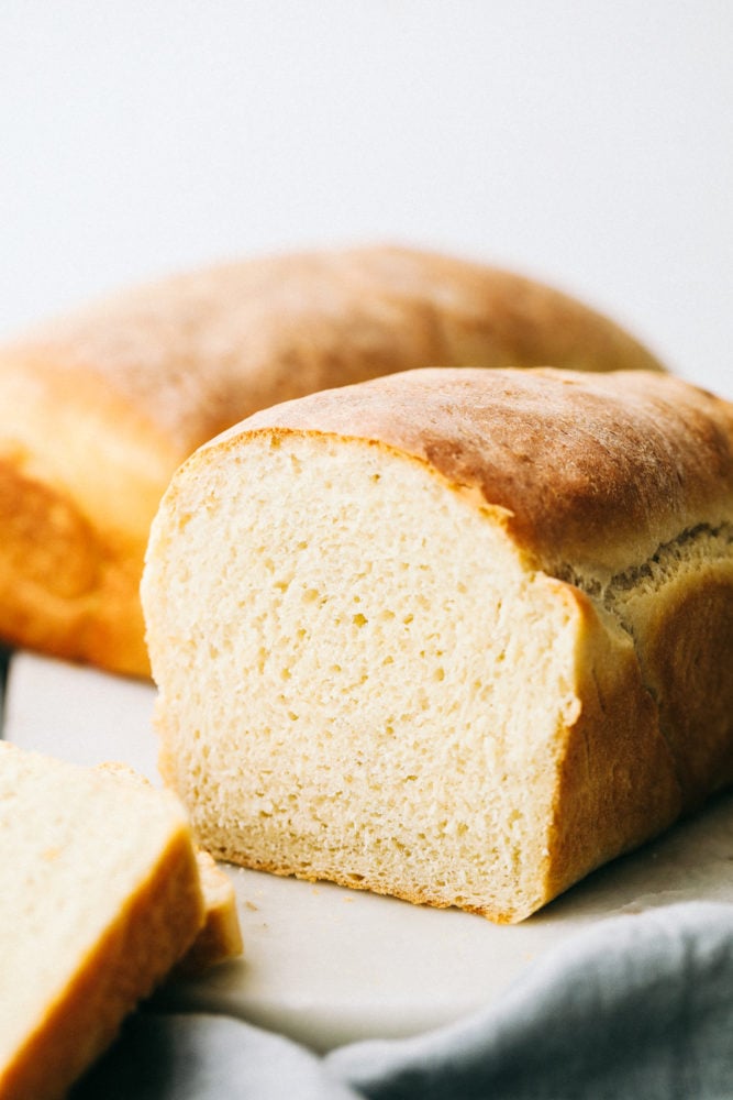 This homemade bread is always a family favorite and can be done so easily with this perfect recipe my grandma handed down to me. Making bread is easier than you think! Homemade bread standing tall and cut in half.