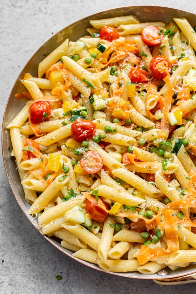 Pasta Primavera is a classic Italian American recipe that's loaded with spring vegetables. It has a light and fresh sauce and is the perfect break from heavier winter foods! Pasta primavera in a skillet.
