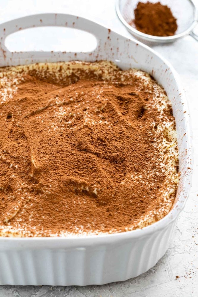 Tiramisu is a popular no-bake Italian dessert meant to feed a crowd. Ladyfinger cookies are dipped in coffee then layered with a sweetened mascarpone cheese filling. The final touch is a sprinkling of cocoa powder on top. sprinkling cocoa powder over tiramisu