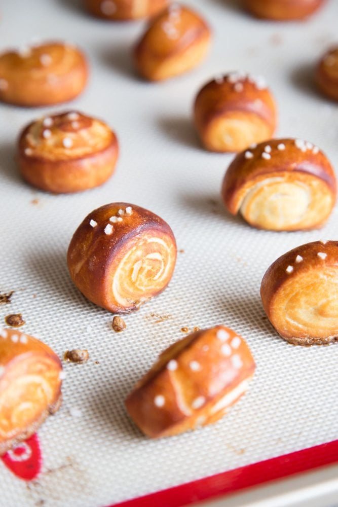 Pretzel Bites are the perfect afterschool snacks, game day appetizers, and popcorn replacement for movie nights. The outside of each pretzel bites is golden brown and chewy, while the inside is soft and fluffy. Baked pretzel bites on a baking tray