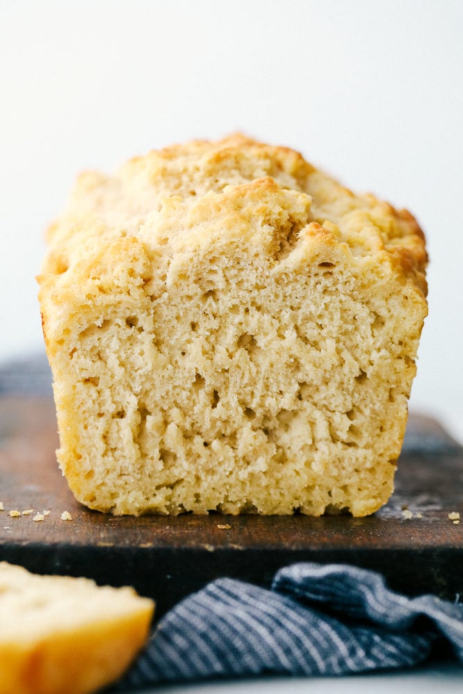 No yeast, No problem! This recipe is a light and fluffy buttery bread that is filled with a special ingredient that substitutes for yeast. You guessed it, beer! With this six ingredient recipe you will be sure to please your family with this homemade bread recipe! Beer bread sliced a piece off to see the thick and soft inside of the bread.