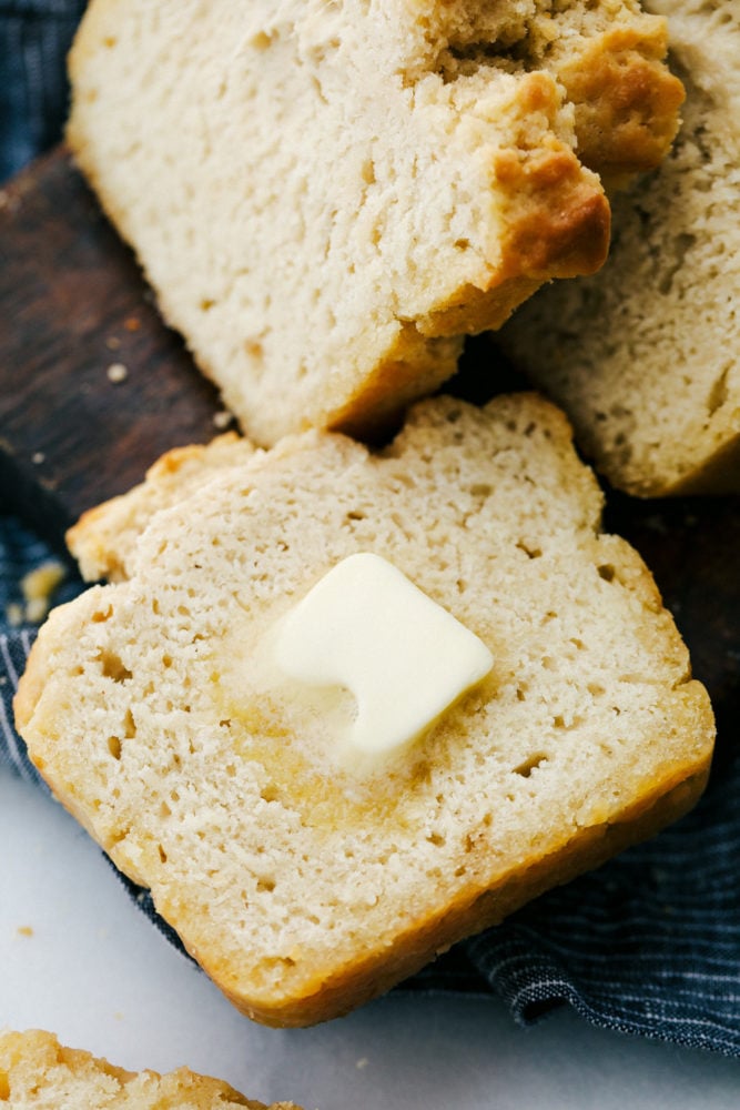 No yeast, No problem! This recipe is a light and fluffy buttery bread that is filled with a special ingredient that substitutes for yeast. You guessed it, beer! With this six ingredient recipe you will be sure to please your family with this homemade bread recipe! Warm buttery bread sliced up with a slice of butter on top that is slowly melting. .