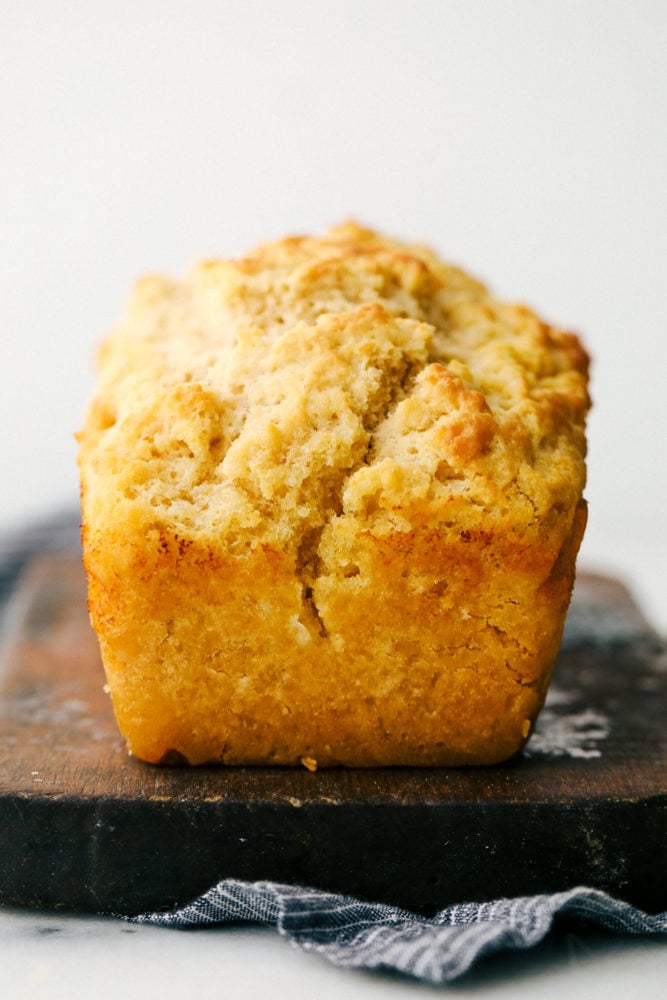 No yeast, No problem! This recipe is a light and fluffy buttery bread that is filled with a special ingredient that substitutes for yeast. You guessed it, beer! With this six ingredient recipe you will be sure to please your family with this homemade bread recipe! Buttery beer bread loaf in a photo.