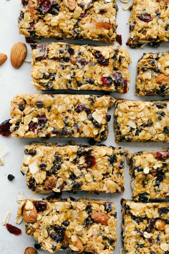 Easy to make chewy granola bars that are homemade filled with regular oats, dried cranberries, salty almonds, mini dark chocolate chips all combined with a sweet honey and a peanut butter flavoring. Snack time just got easier with these tasty bars!ย Sliced up granola bars.