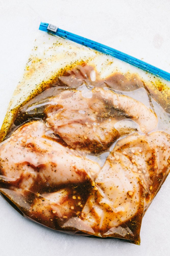This absolutely perfect chicken marinade will make your chicken so tender and juicy you will be amazed!!ย This will be the one recipe that you use on repeat all summer! Chicken marinating in a ziploc bag.