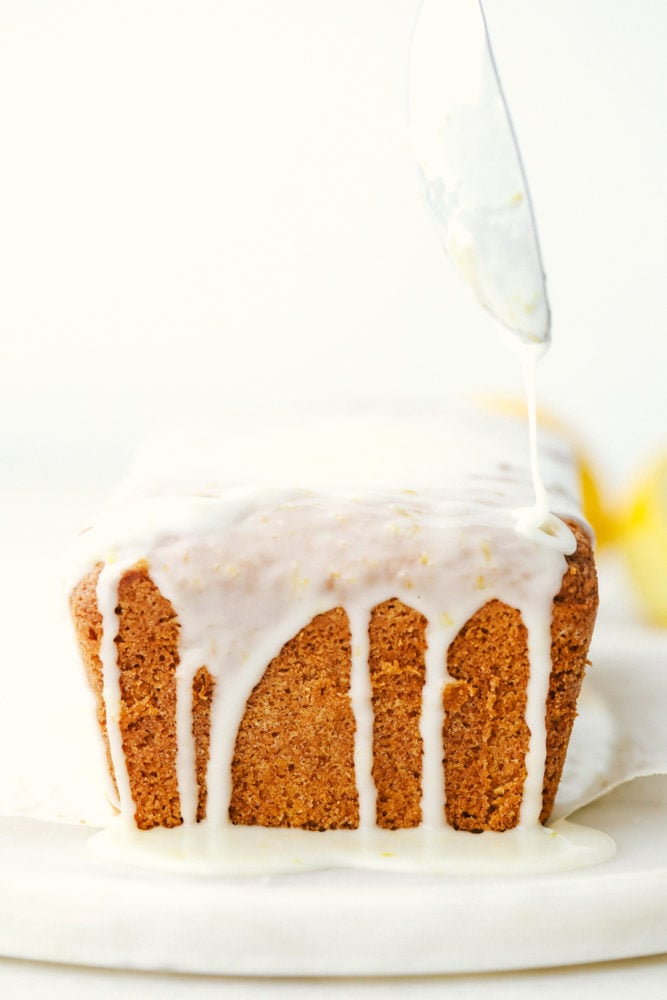 Glazed Lemon Bread is a soft, moist bread bursting with citrus lemon flavor and topped with a shell of sweet lemon glaze. This quick and easy homemade bread is great for sharing or savoring!! Finished glazed lemon bread loaf.