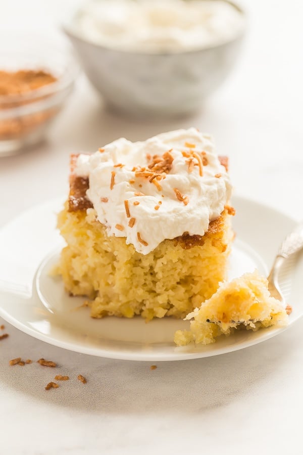 This Pineapple Cake recipe is made from scratch with crushed pineapple and topped with cream cheese whipped cream for a light but decadent treat! #pineapple #cake #baking #dessert pineapple cake with whipped cream