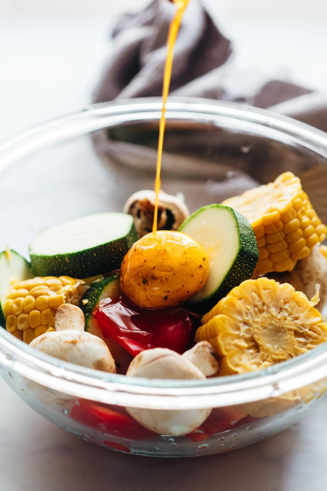 Grilled Vegetable Kabobs are tossed in a spicy lemony marinade and grilled till lightly charred. They soak up all the flavour and become juicy, tender but remain slightly crunchy. Pouring marinade over grilled vegetable kabobs