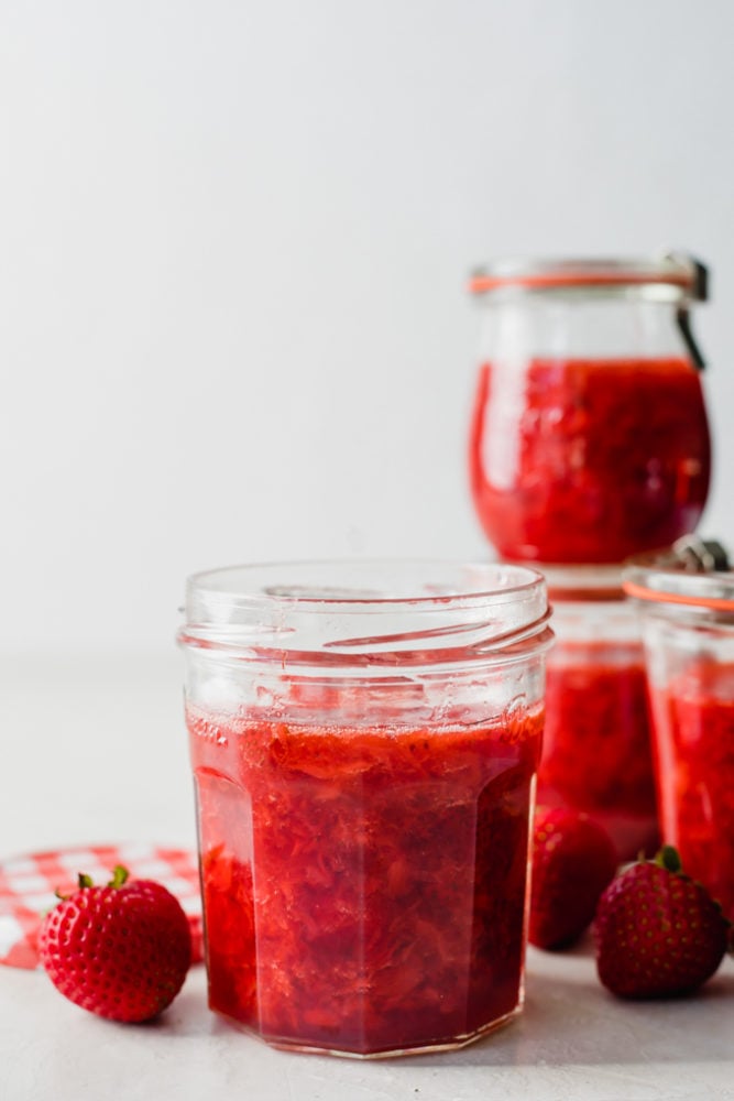Homemade Strawberry Jam use all those fresh, juicy berries to make your own jam at home! No canning required. Simply store this jam in your refrigerator or freezer to enjoy. Homemade strawberry jam in a glass jar.