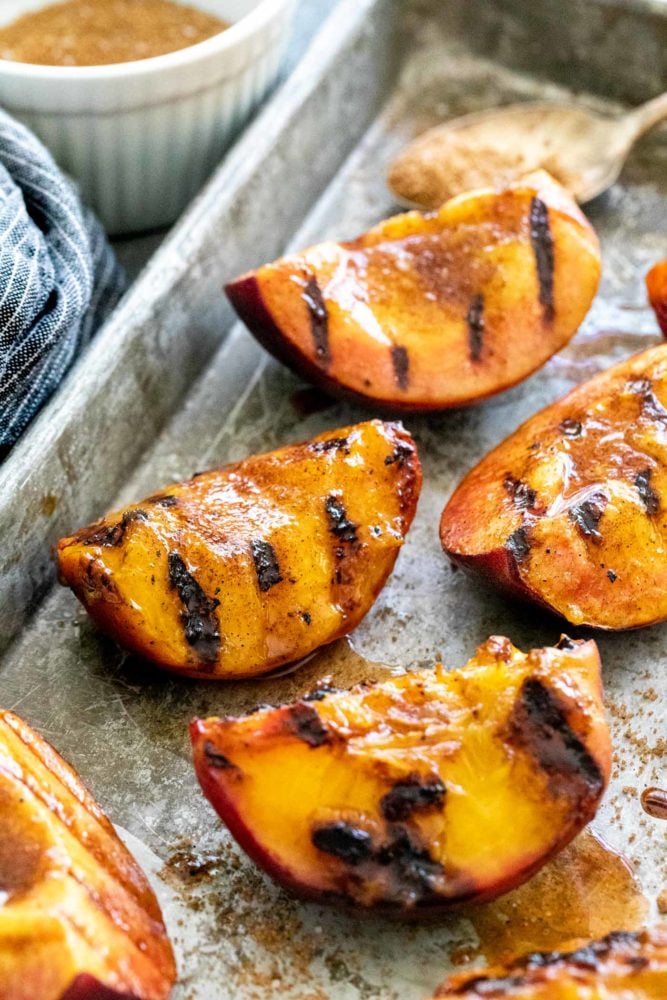 Brown sugar grilled peaches are a summertime delight. Ripe peaches are lightly charred on the barbecue then sprinkled with a sweet spiced topping that transforms into a glaze. Perfect as a quick dessert or add it to a fresh salad.ย Brown Sugar Grilled Peaches