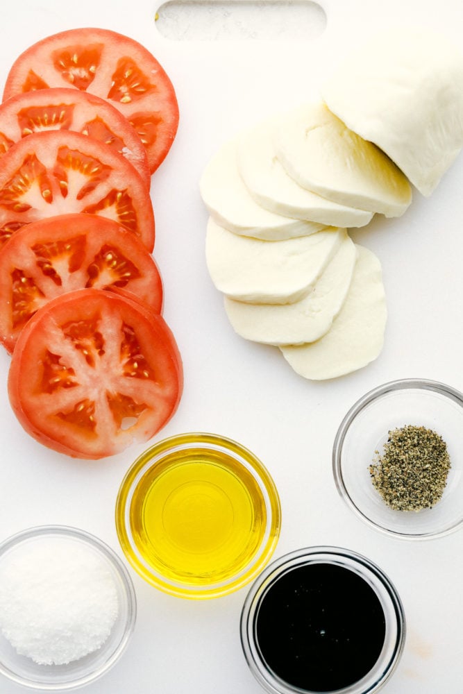 Caprese Salad is made with layers of fresh tomato slices, basil, and mozzarella cheese, then drizzled with balsamic glaze and topped with a sprinkle of salt and pepper. It is the perfect summer meal that you will crave all year! Ingredients for Caprese salad.