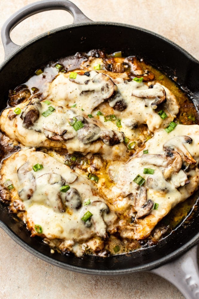 Chicken Lombardy is an insanely delicious cheesy version of Chicken Marsala baked to perfection with mozzarella and scallions. Ready in about 30 minutes! Chicken Lombardy in a cast iron skillet
