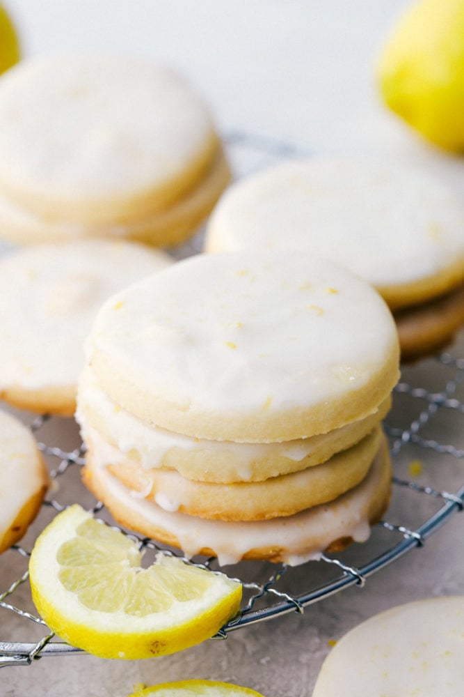 Buttery Lemon Shortbread Cookies with a Glaze are light and fresh with vibrant sweet and sour flavors that are surprisingly easy to create! Every bite is packed with a burst of lemon flavor and the shortbread has the perfect dense, buttery texture that will make this your new favorite cookie! A stack of lemon shortbread cookies.