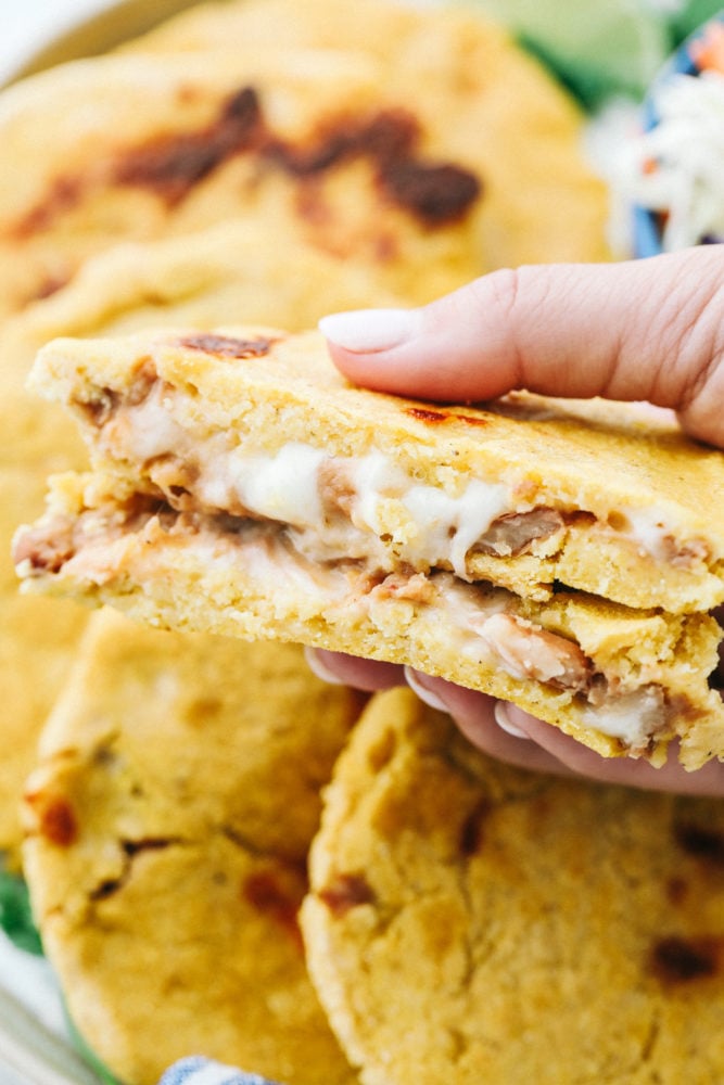 Easy Bean and Cheese Pupusas are handmade griddle cakes filled with savory beans and cheese. They are cheap and easy to make, but just beware because they are addicting! Close up on the inside of bean and cheese pupusas