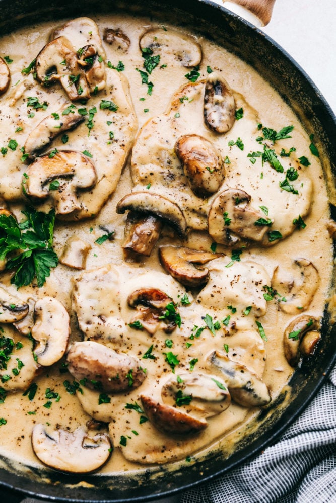 Smothered Pork Chops in an Amazing Mushroom Gravy are tender, savory, and satisfying.ย This one pan dinner is the perfect comforting dinner at home that your family will love! Smothered pork chops in the pan.