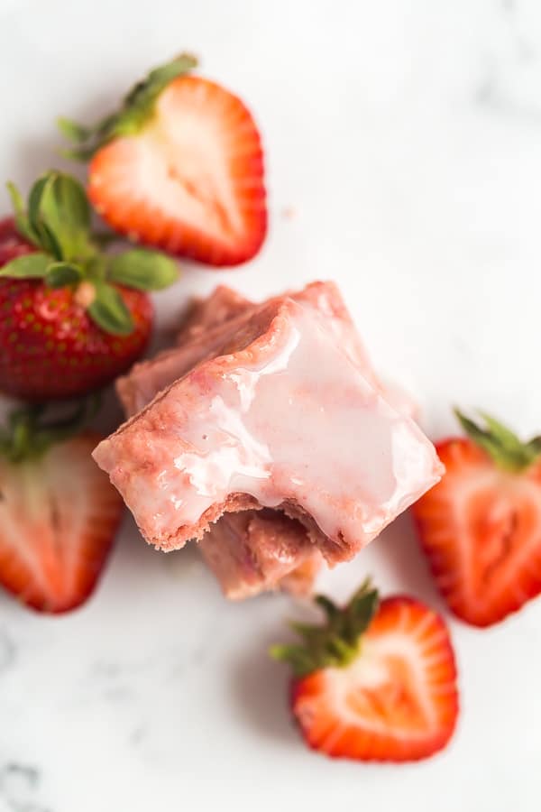 These 2 INGREDIENT Strawberry Brownies are perfect for strawberry season! Made with cake mix and fresh strawberries, they are dense and chewy with a light strawberry glaze. strawberry brownies stack overhead