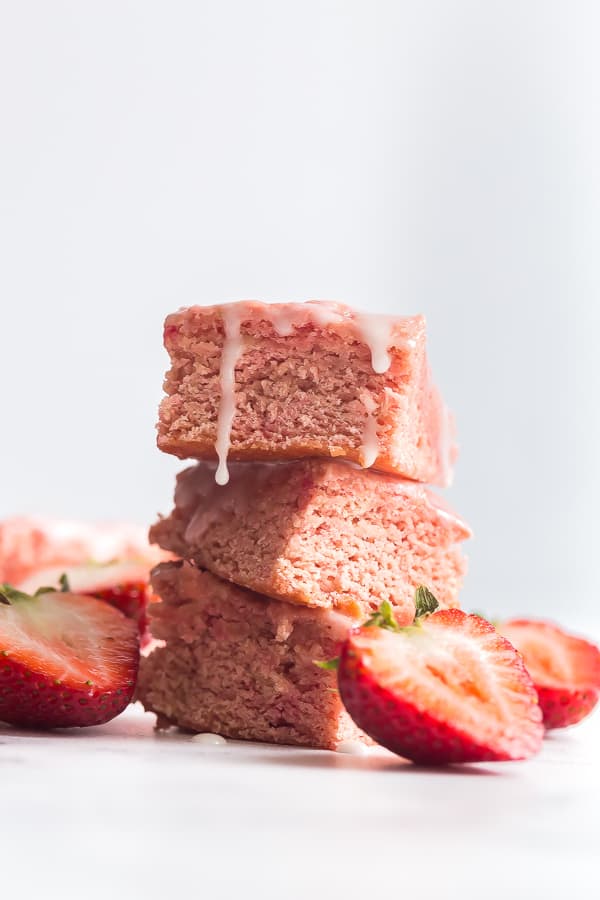 These 2 INGREDIENT Strawberry Brownies are perfect for strawberry season! Made with cake mix and fresh strawberries, they are dense and chewy with a light strawberry glaze. stack of 3 strawberry brownies