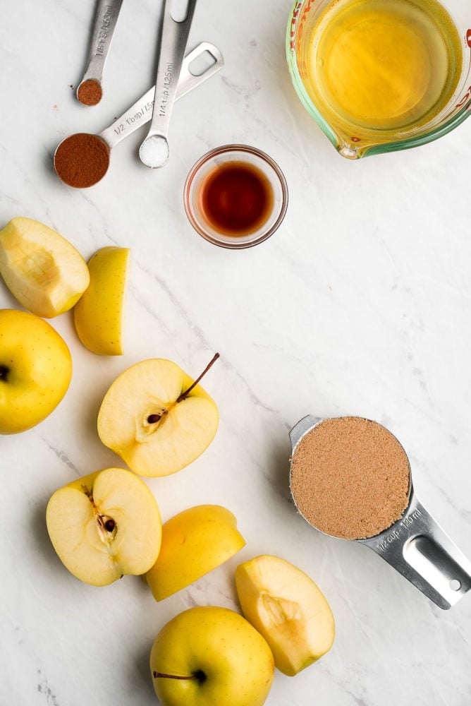 Apple Butter is a sweet velvety concentrated apple spread that youโll want to put on everything. It requires just a few ingredients and a little bit of patience to make this yummy jam like condiment. Apples cut in half and quarters, teaspoons of spices, a small bowl of vanilla extract, a liquid measuring cup of apple cider, and a measuring cup of brown sugar.