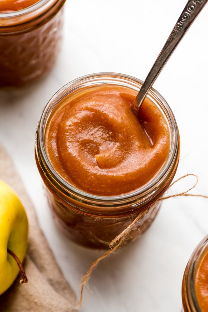 Apple Butter is a sweet velvety concentrated apple spread that youโll want to put on everything. It requires just a few ingredients and a little bit of patience to make this yummy jam like condiment. A jar of silky smooth Apple Butter with a spoon in it.