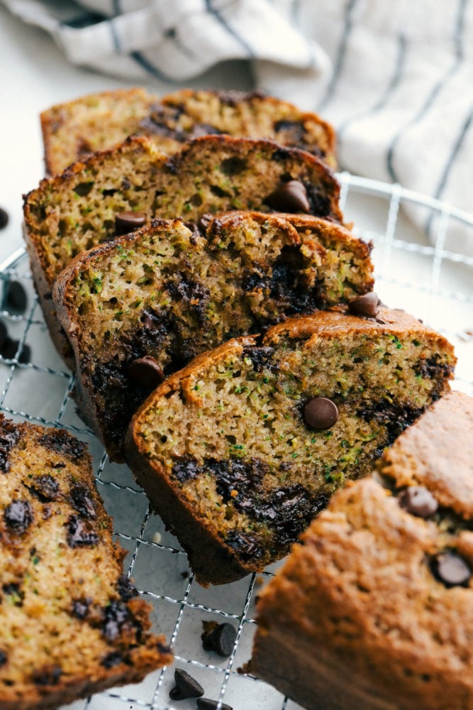 Perfect Chocolate Chip Zucchini Bread is soft and sweet and incredibly easy to make from scratch at home.ย It's the best zucchini bread and tastes amazing with coffee for a satisfying breakfast or as delicious afternoon snack! Sliced Chocolate Chip Zucchini Bread on a cooling rack.