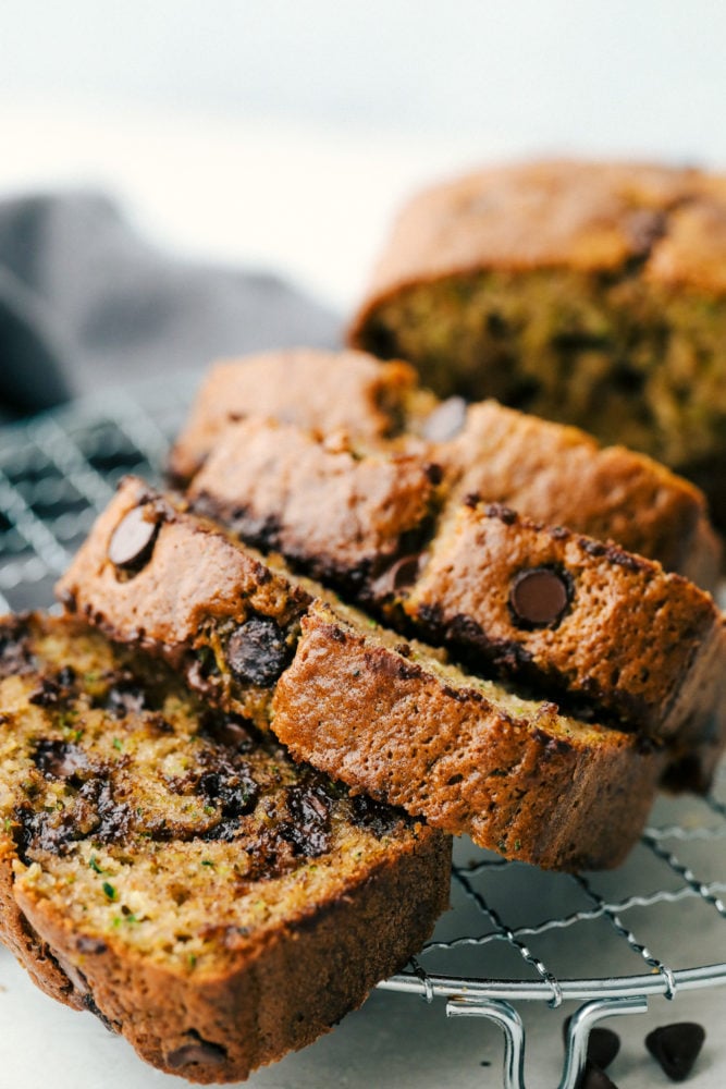 Perfect Chocolate Chip Zucchini Bread is soft and sweet and incredibly easy to make from scratch at home.ย It's the best zucchini bread and tastes amazing with coffee for a satisfying breakfast or as delicious afternoon snack! Sliced Zucchini Bread on a cooling rack.