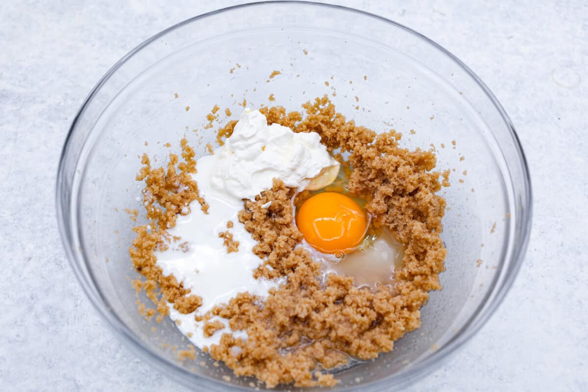 Perfect Pineapple Upside-Down Cake is a moist and fruity pineapple cake topped with caramelized pineapple rings and sweet maraschino cherries. It's no wonder this classic dessert has been a tried and true favorite for years! First photo of the wet ingredients added to a bowl.