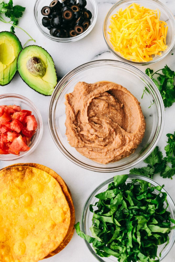 These Tostadas are easy to make and layered with flavorful toppings that make this main dish one of the best! Create a delicious dinner right at home within minutes! Optional toppings for tostadas in clear, glass bowls.