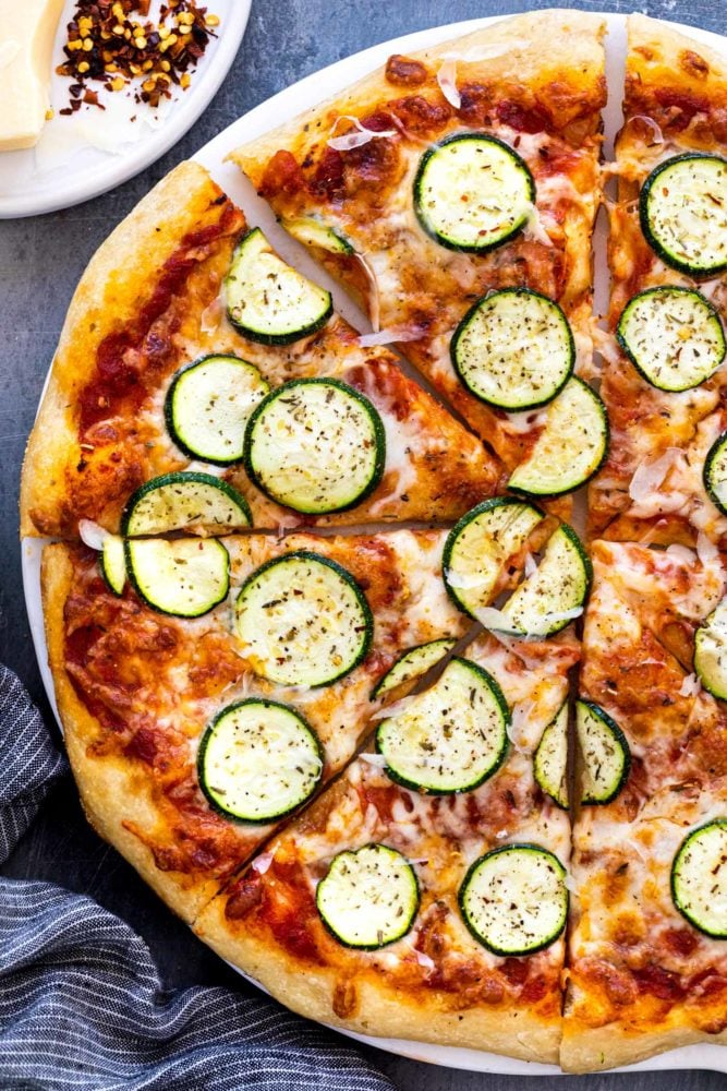This easy zucchini pizza recipe is the perfect vegetarian meal when you're craving a slice. Fresh dough is topped with a savory red sauce, mozzarella cheese, and thin slices of zucchini. The pie is baked until the crust is crispy and cheese is hot and bubbly. Zucchini Pizza