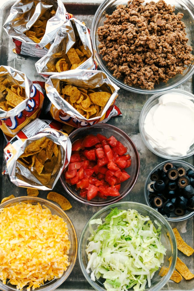 Walking Tacos are quick and easy deconstructed tacos that are made and served right in a chip bag. Great for active parties or on the go meals because they are filling and fast! Overhead view of all the ingredients in a walking taco.