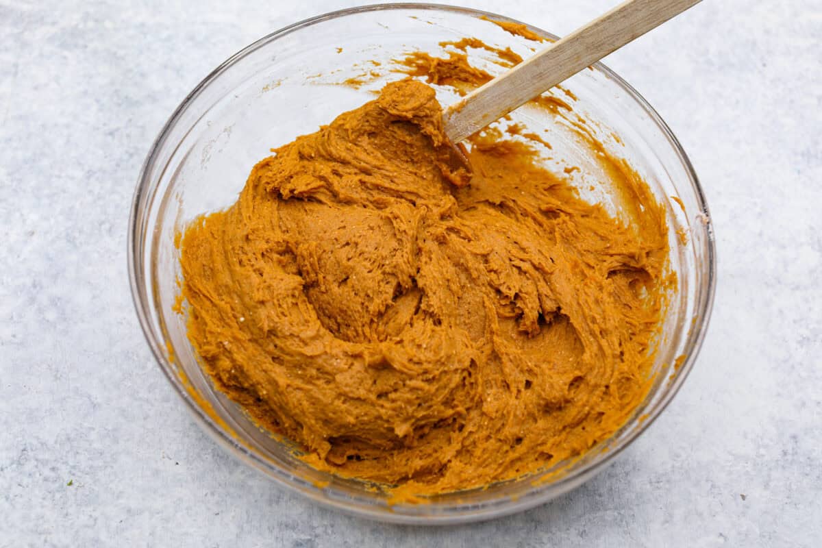 Easy as 1,2,3, these delicious pumpkin chocolate chip cookies are super quick and tasty! They are light, fluffy, and packed with pumpkin flavor and silky milk chocolate. With only three ingredients, it can’t get much easier than that! Overhead shot of pumpkin puree mixed in with the spiced cake mix.