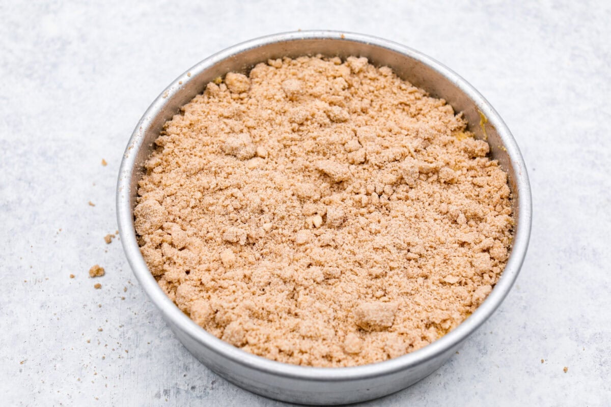 This classic cinnamon coffee cake is loaded with decadent cinnamon sugar swirls and topped with crumbly cinnamon streusel. It's the perfect treat to share at any brunch, book club, or dessert for any night of the week. The warm, satisfying aroma will fill your heart and your home! Overhead shot of the second layer of the coffee cake with the streusel crumble over the top.
