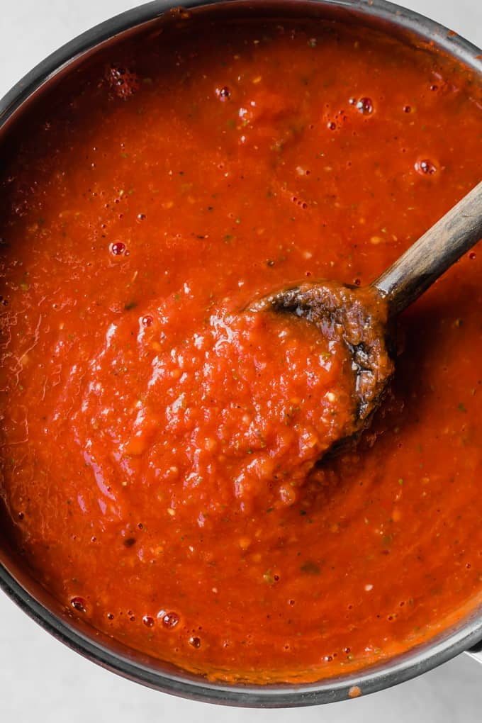 Easy Homemade Tomato Sauce. This quick and easy recipe uses minimal ingredients that you most likely have in your pantry! Simmer slowly to make a thick, flavorful sauce that is perfect for smothering noodles, or using on a pizza. Tomato sauce and wooden spoon in a pan.
