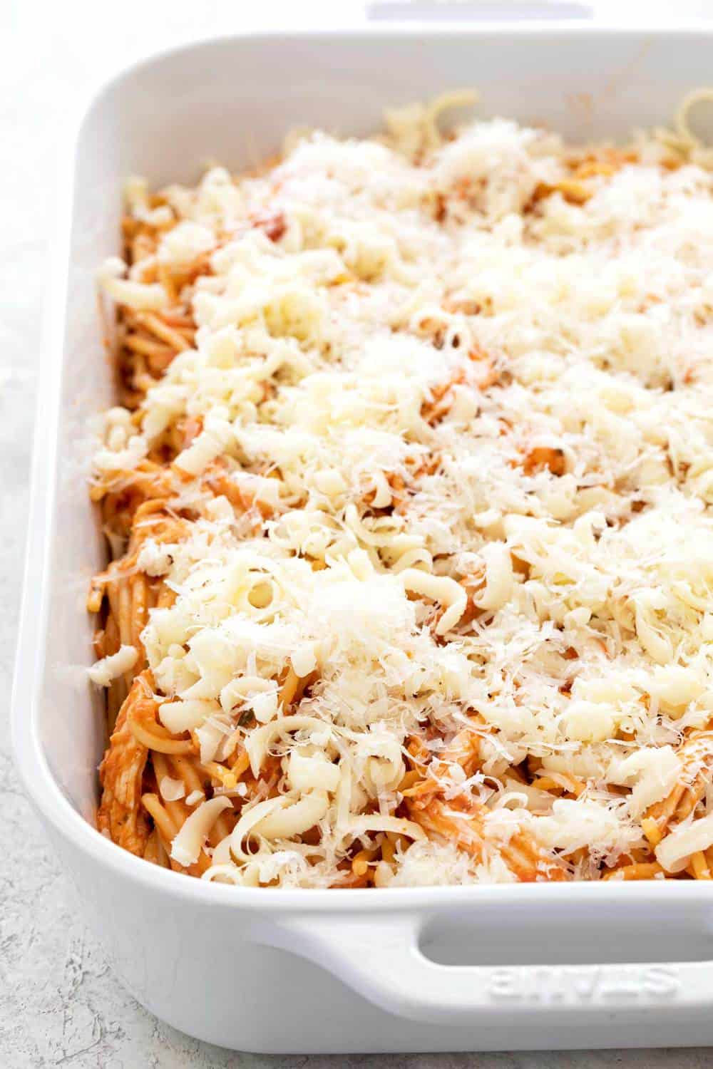Baked chicken spaghetti is an easy dinner casserole to feed a family. Tender pieces of chicken tossed with tender noodles and a creamy tomato sauce. Lots of shredded cheese in a casserole dish with pasta