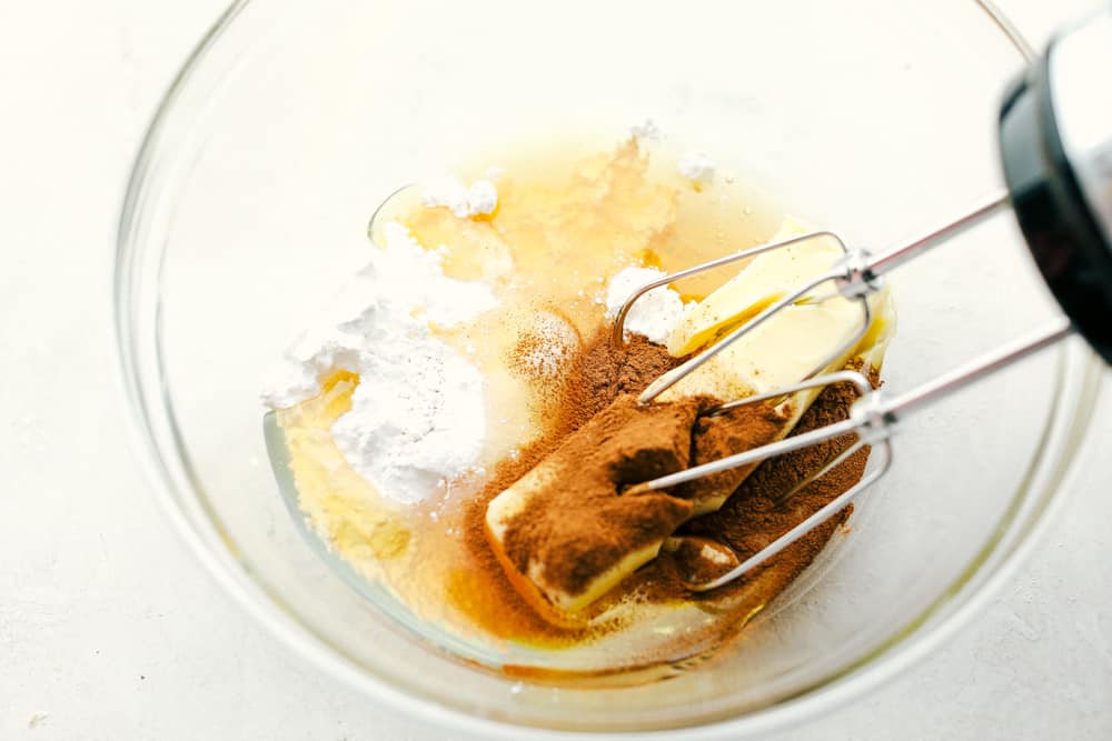 This cinnamon honey butter is rich, creamy and a smooth blend that is spreadable and ready in minutes. This is even better than Texas Roadhouse butter! Mixing together cinnamon honey butter in a glass bowl with a mixer.