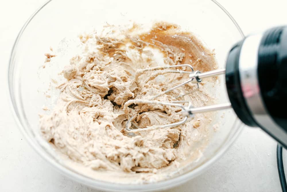 This cinnamon honey butter is rich, creamy and a smooth blend that is spreadable and ready in minutes. This is even better than Texas Roadhouse butter! Cinnamon honey butter mixed together in a clear glass bowl with a mixer.