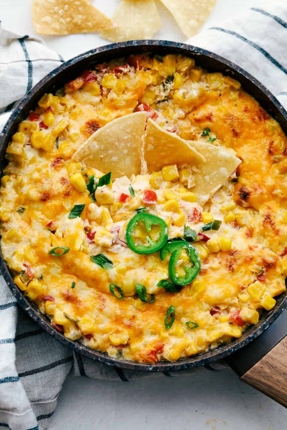Hot Corn Dip is super cheesy, packed with flavor and such a crowd pleaser. This always one of the first dips to disappear! Hot Corn Dip with onions, peppers, jalapeno and ooey gooey cheese, served with corn chips.
