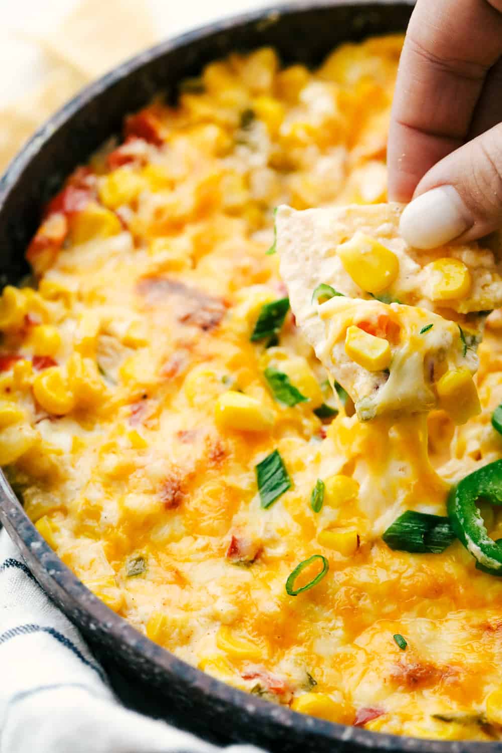 Hot Corn Dip is super cheesy, packed with flavor and such a crowd pleaser. This always one of the first dips to disappear! Hot Corn Dip with onions, peppers, jalapeno and ooey gooey cheese, served with corn chips.