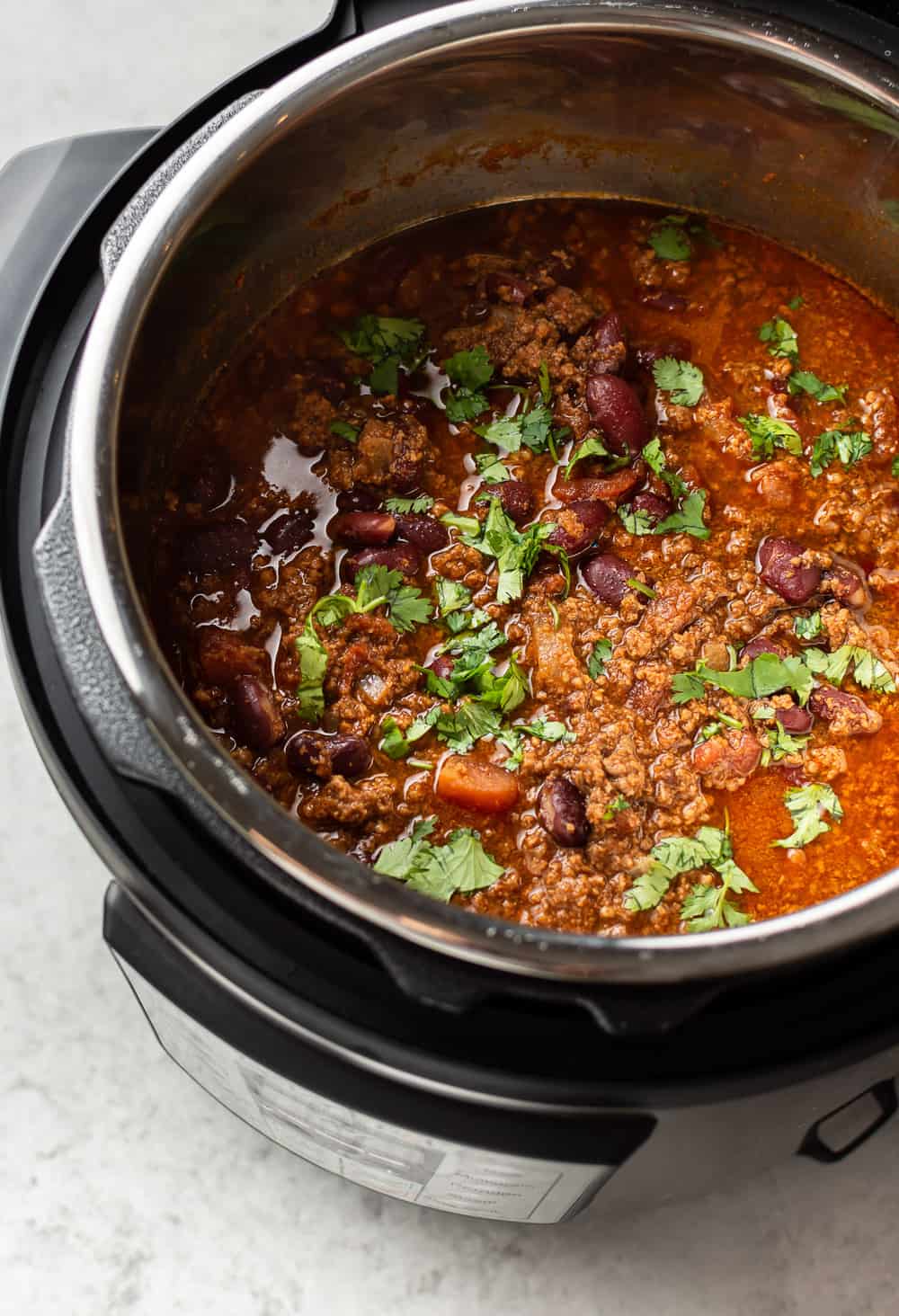 Instant Pot Chili is simple to make and hearty. The electric pressure cooker builds amazing flavors in a short time, and everyone will love loading up their bowls with their favorite toppings! close-up of beef chili in an Instant Pot