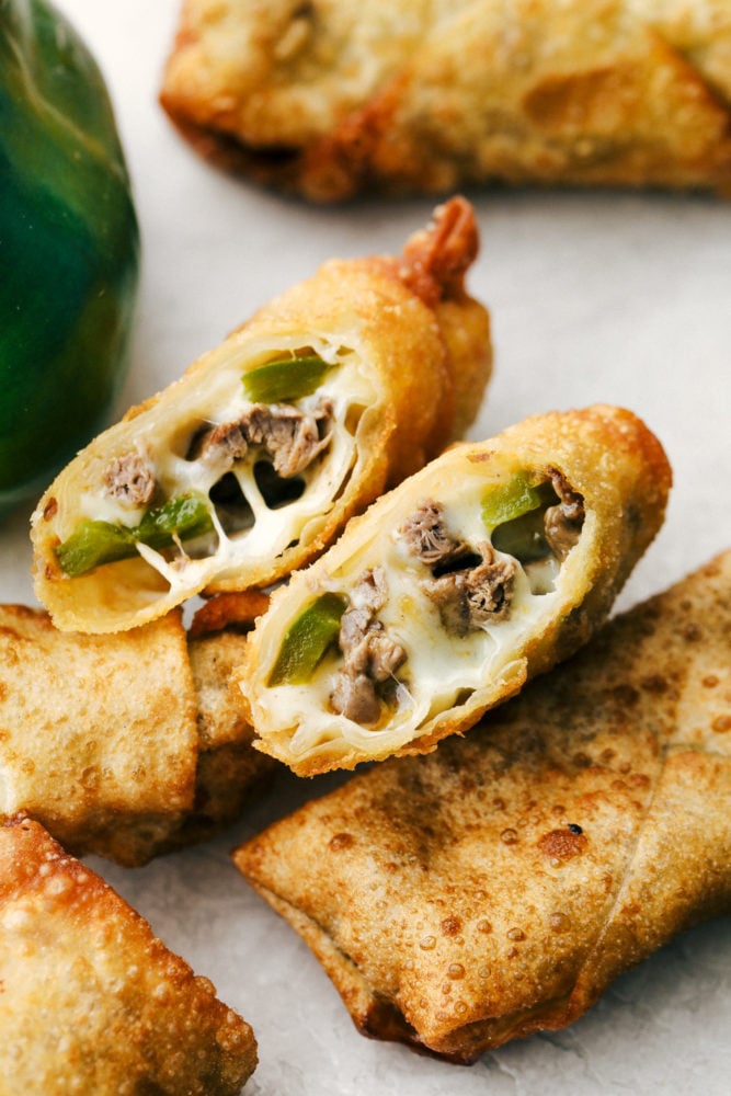 Tender meat, sautรฉed peppers and onions is smothered with cheese and wrapped in egg roll wrappers and fried to perfection in these Philly Cheesesteak Egg Rolls. This is going to be your go to appetizer or snack when you want to impress without a lot of stress. Crispy on the outside, ooey gooey on the inside Philly Cheesesteak Egg Rolls