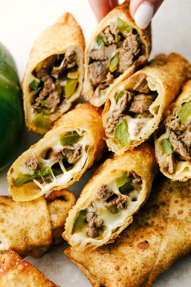 Tender meat, sautรฉed peppers and onions is smothered with cheese and wrapped in egg roll wrappers and fried to perfection in these Philly Cheesesteak Egg Rolls. This is going to be your go to appetizer or snack when you want to impress without a lot of stress. Crispy on the outside, ooey gooey on the inside Philly Cheesesteak Egg Rolls